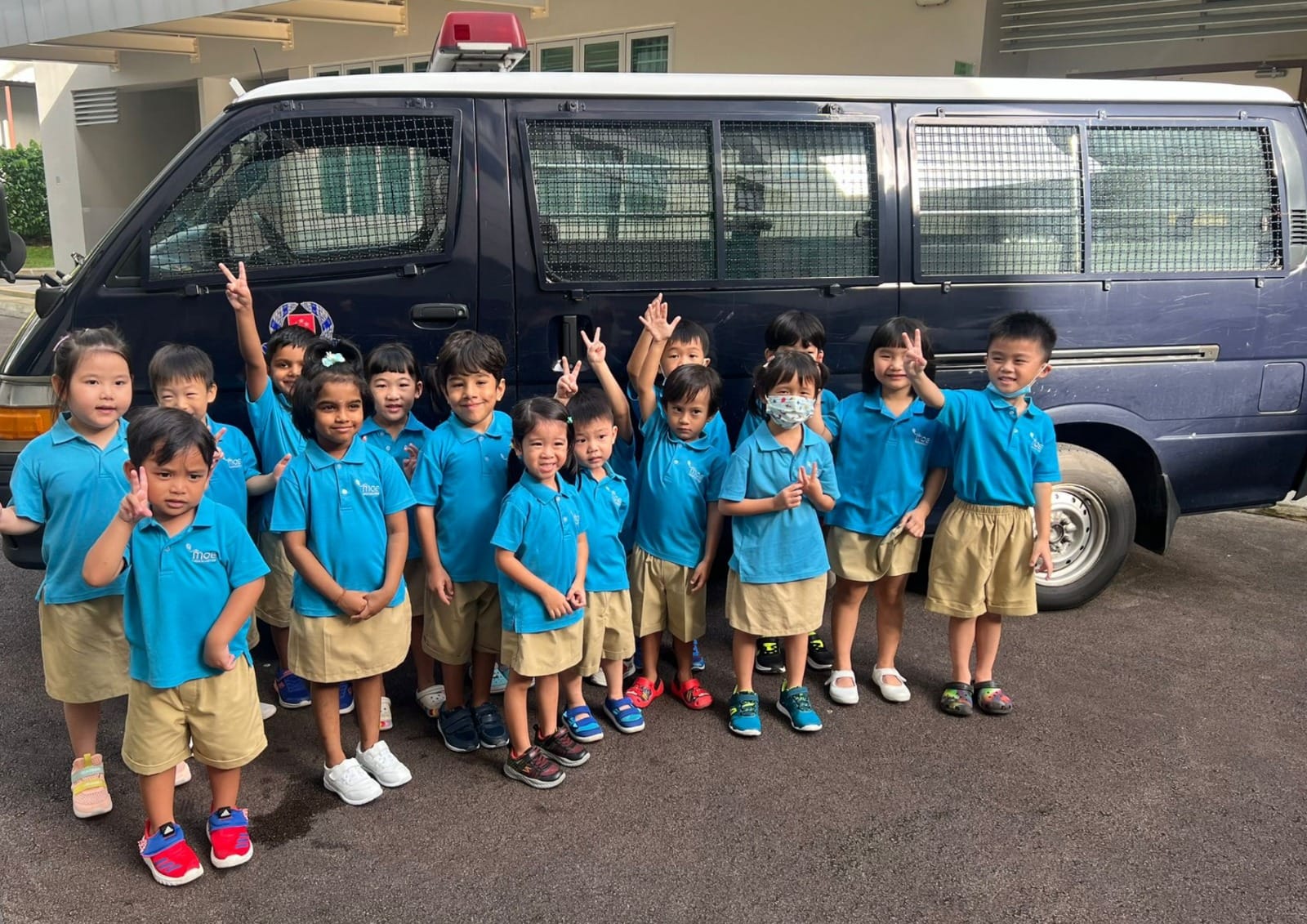 MOE Kindergarten children visit Pei Tong Primary School and pose for a group photo beside a police transport vehicle during a school familiarisation programme.
